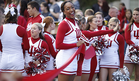 The IU cheerleaders line up to hold the ribbon across Woodlawn Avenue for the ribbon-cutting cere...