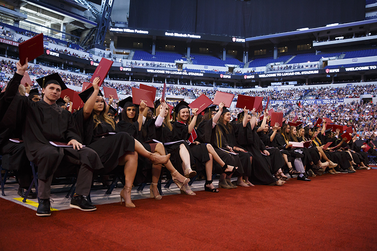 Graduates wave their diplomas in celebration during IUPUI’s commencement.