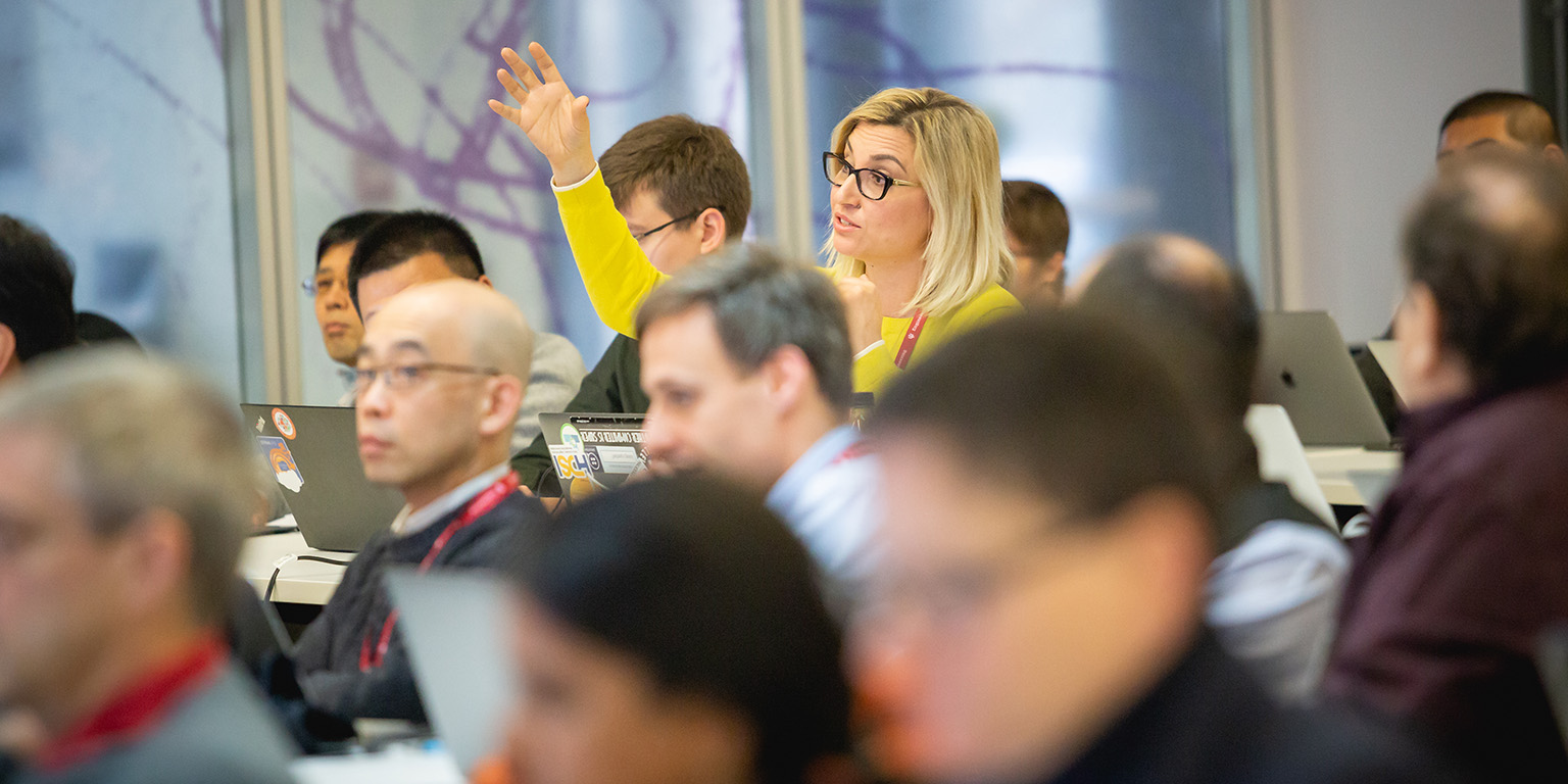 A woman raises her hand to ask a question 