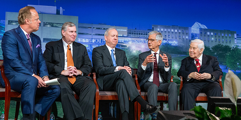 Four former Indianapolis mayors are seated and having a conversation on a stage with a moderator