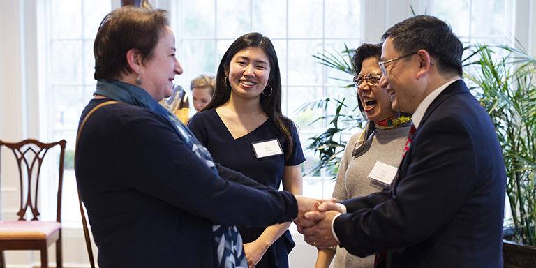 Jenny Huang stands nearby while her family greets IU Provost Lauren Robel