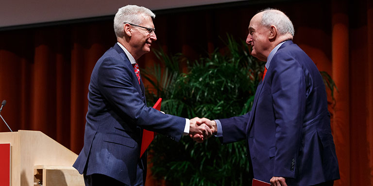 Michael Weiss shakes hands with IU President McRobbie