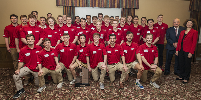 IU President and First Lady McRobbie stand with the IU men's swimming and diving team