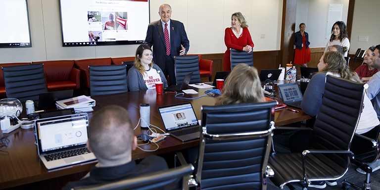 IU President McRobbie talks with people seated around a long table