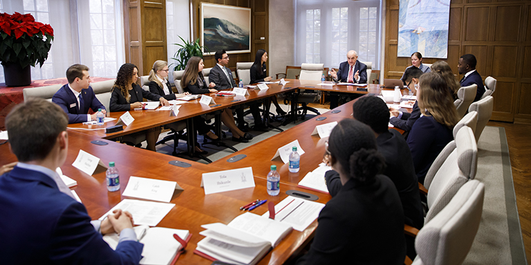 Students sit around a conference table with IU President McRobbie